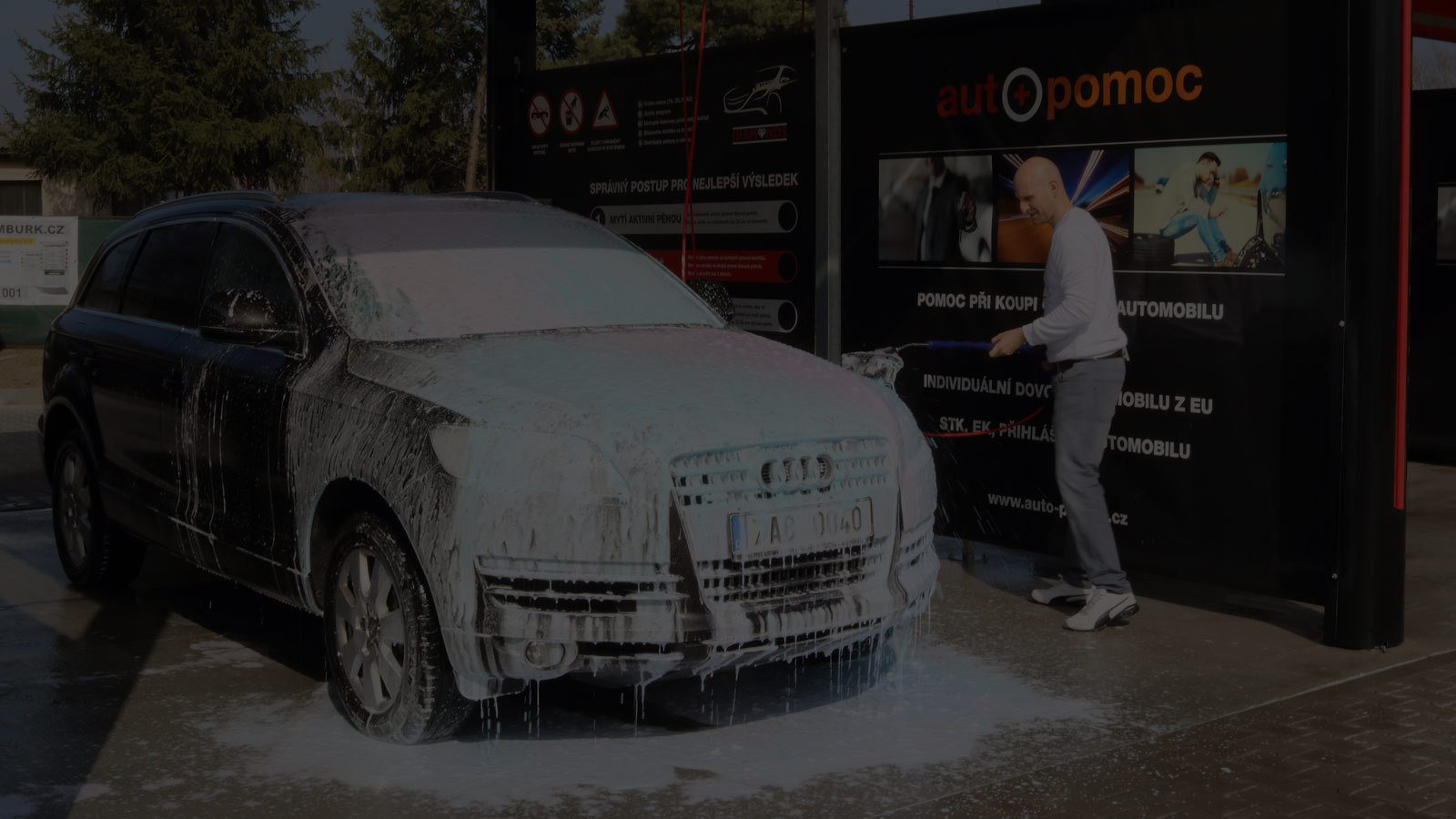Zatmavená fotka na pozadí. Pohled na bezkontaktní mytí osobního vozu v automyčce Diamonds v Nymburce.